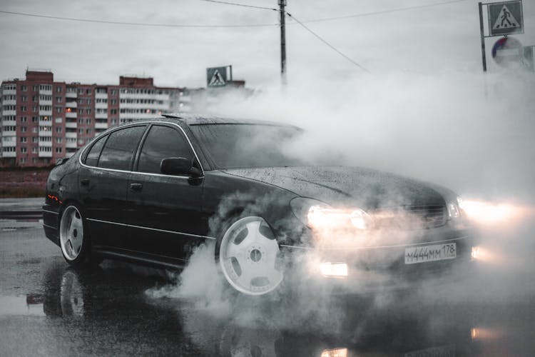 A Black Car Covered With Thick White Smoke