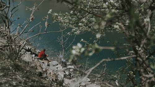 A Man Sitting Near a River