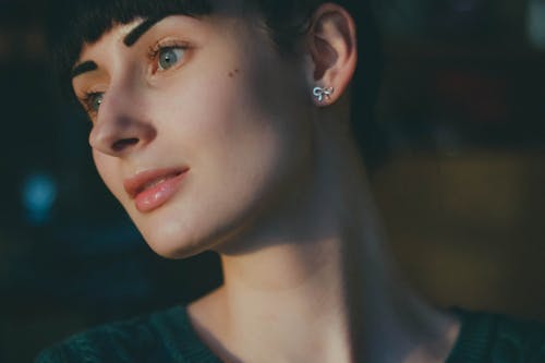 Woman Wearing Silver Earrings and Green Shirt