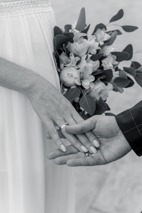 Free A tender black and white capture of a couple exchanging rings during their wedding ceremony. Stock Photo