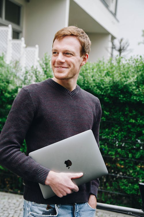 Man in Black Sweater Holding Macbook