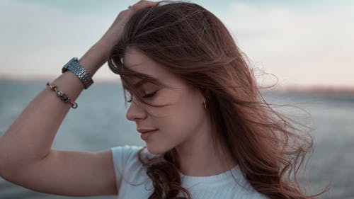 Woman in White Shirt Touching her Hair