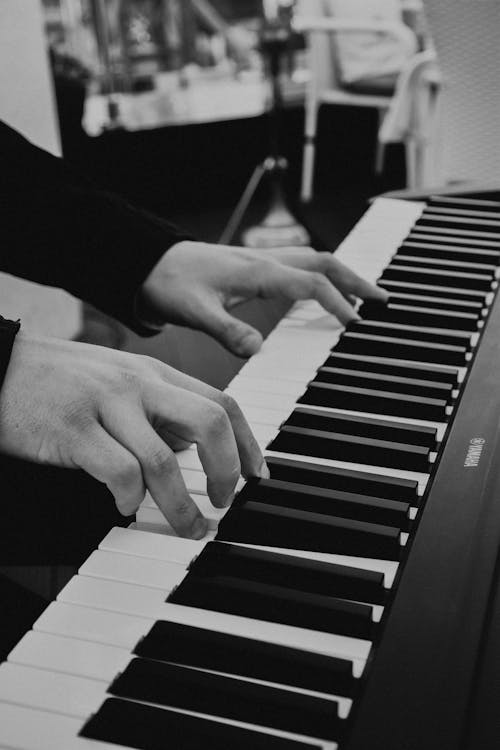 Grayscale Photo of a Person Playing Piano