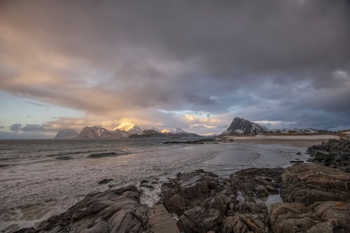 Gratis arkivbilde med bølger, dramatisk himmel, fjellkjede