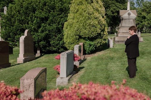 Free Woman In Black Outfit Standing In Front Of A Grave Stock Photo