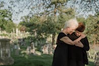 Woman in Black Dress Hugging Woman in Black Dress