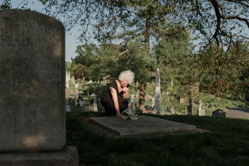 Free Photo of an Elderly Woman Grieving at a Grave Stock Photo