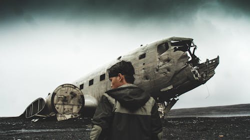 Hombre Vestido Con Chaqueta Con Capucha Negra Y Gris Cerca De Aviones Estrellados