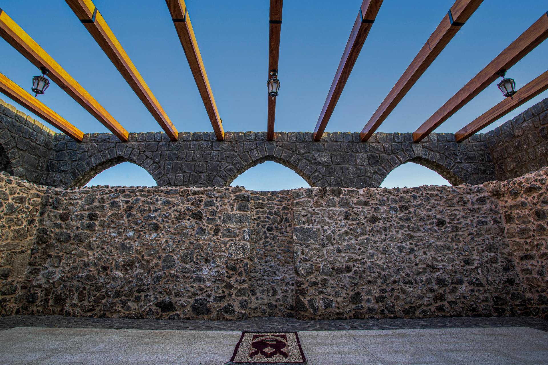 Stone arch wall with wooden beams in Yanbu, Saudi Arabia showcasing traditional architecture.