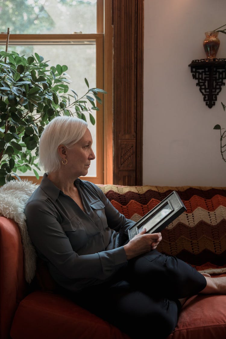 Old Woman Holding A Picture Frame