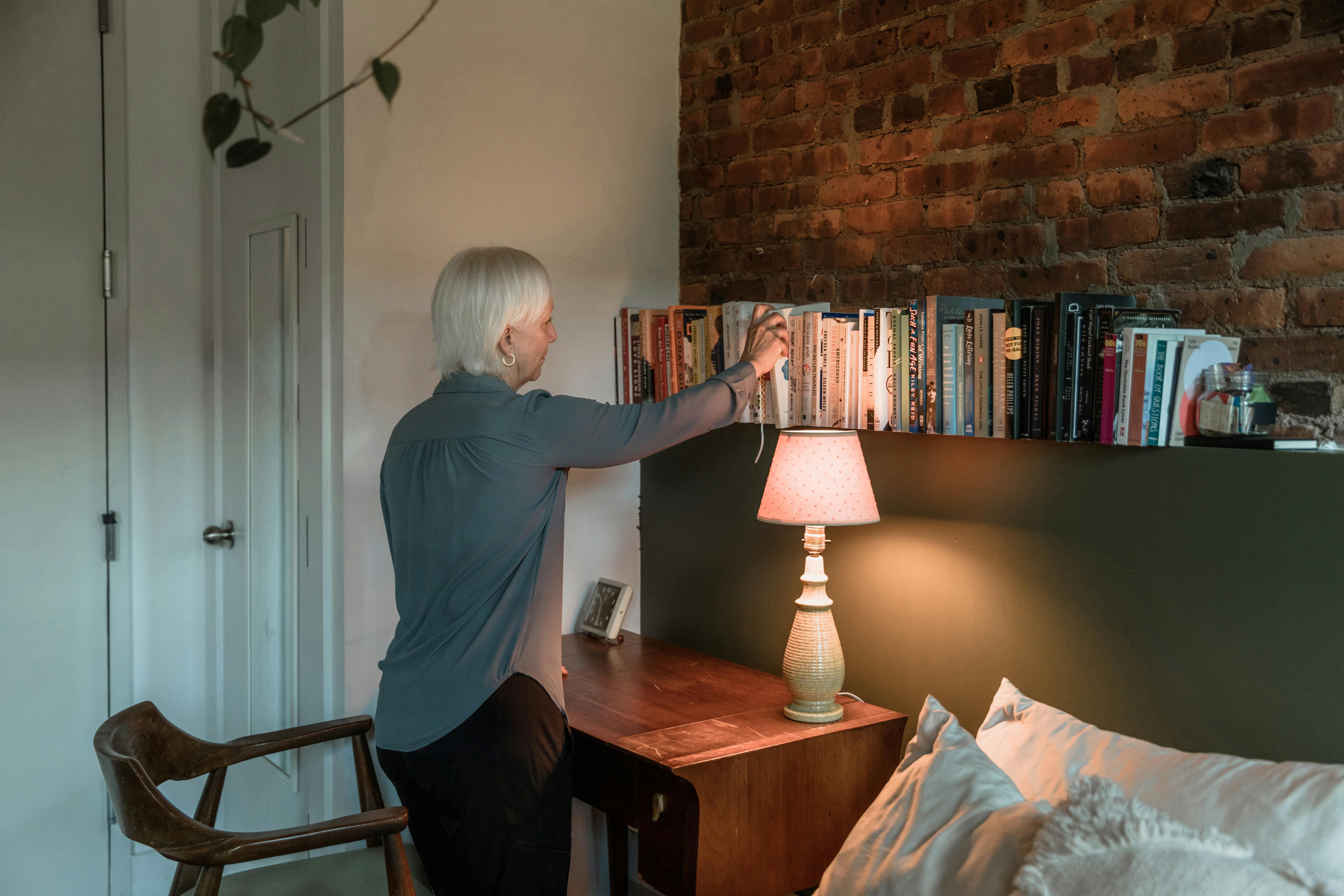 Person using a folding chair in a cozy den with soft reading light and bookshelf