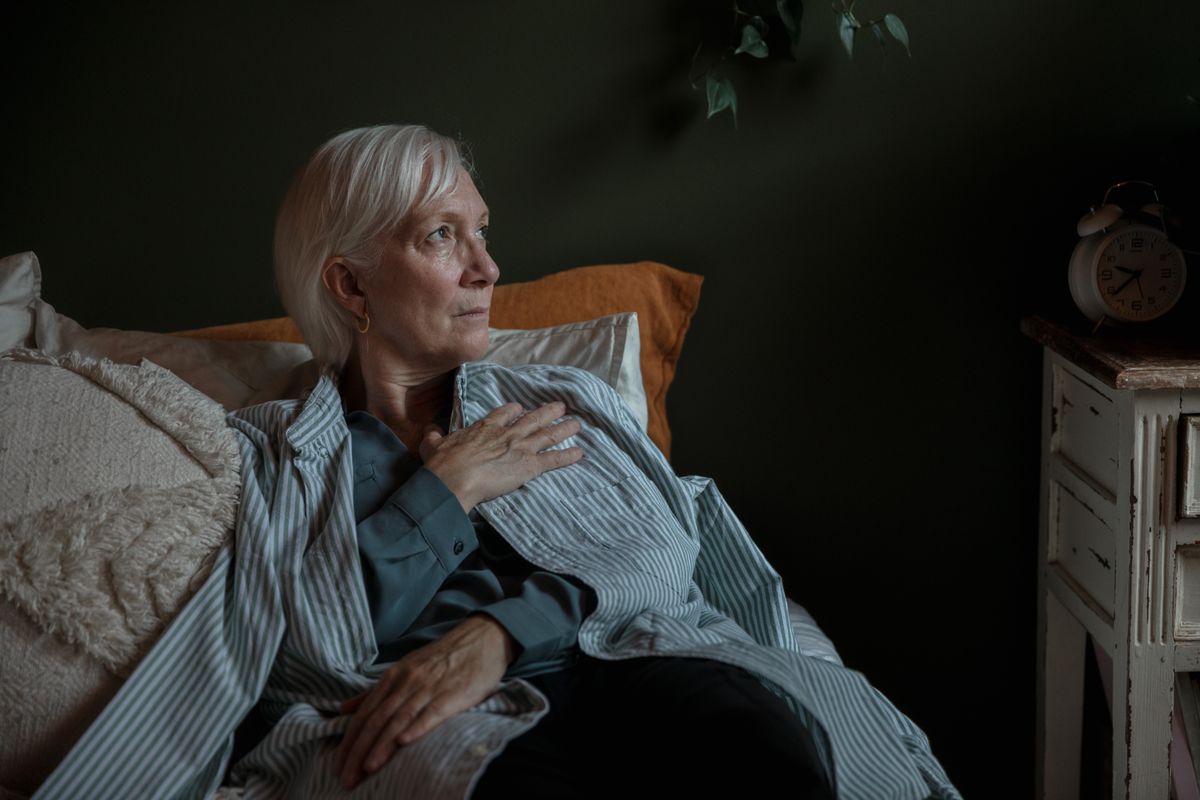 Senior woman lying awake in bed looking thoughtful