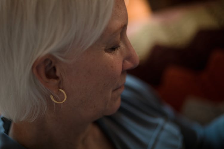 Woman Wearing A Gold Earring Looking Down