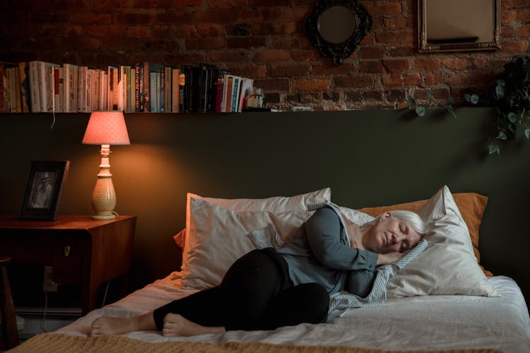 An Elderly Woman Sleeping Peacefully On Her Bed