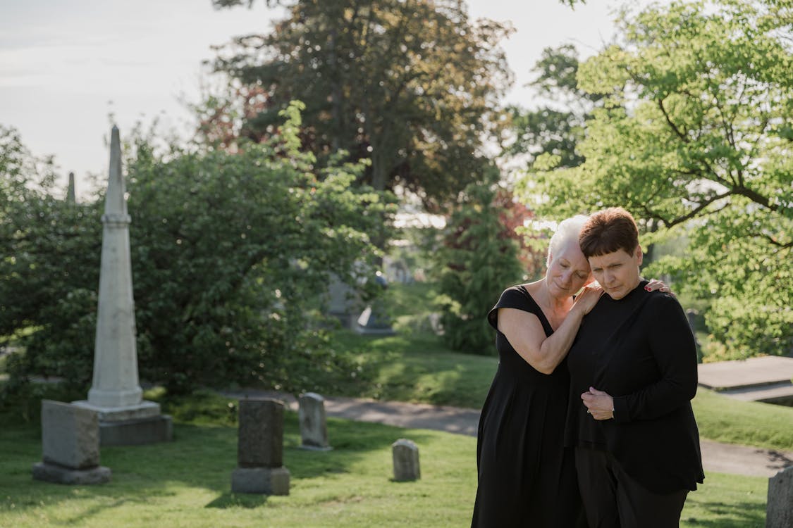 Free Women Dressed in Black Mourning a Person on a Cemetery  Stock Photo