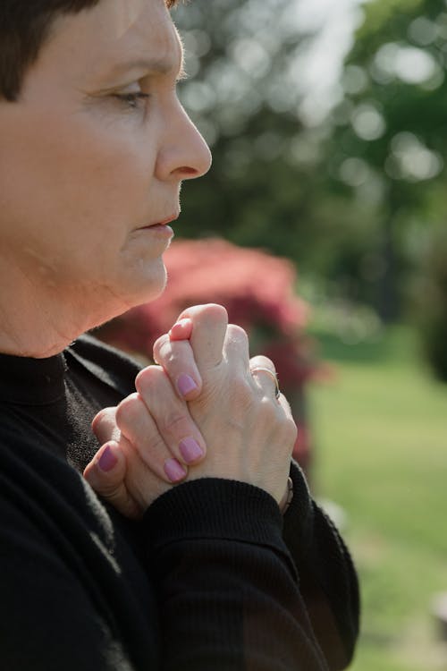 Close-up Shot of a Woman in Black Long Sleeves Holding Her Own Hands