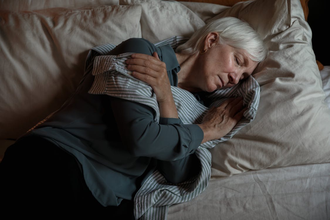 Free An Elderly Woman Lying on the Bed Stock Photo