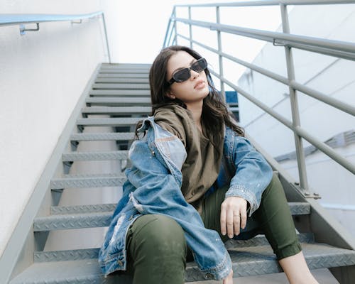 A Pretty Woman in Denim Jacket Sitting on the Stairs