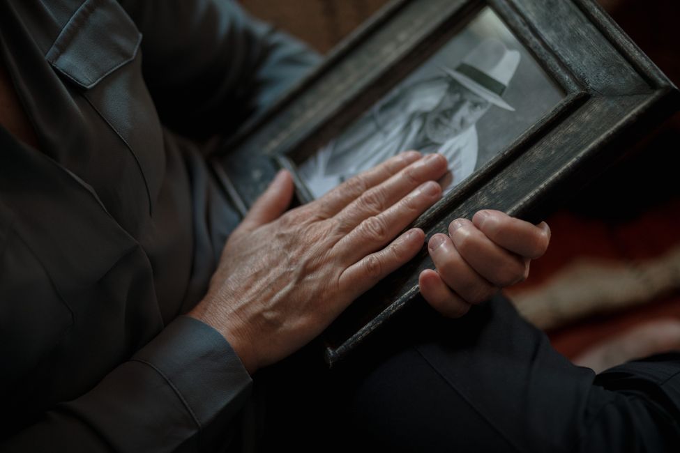 Elderly hands holding photograph