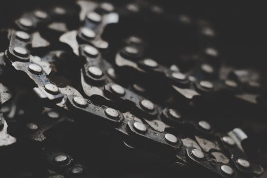 Detailed macro shot of a mechanical bicycle chain and gears, showcasing texture and wear.