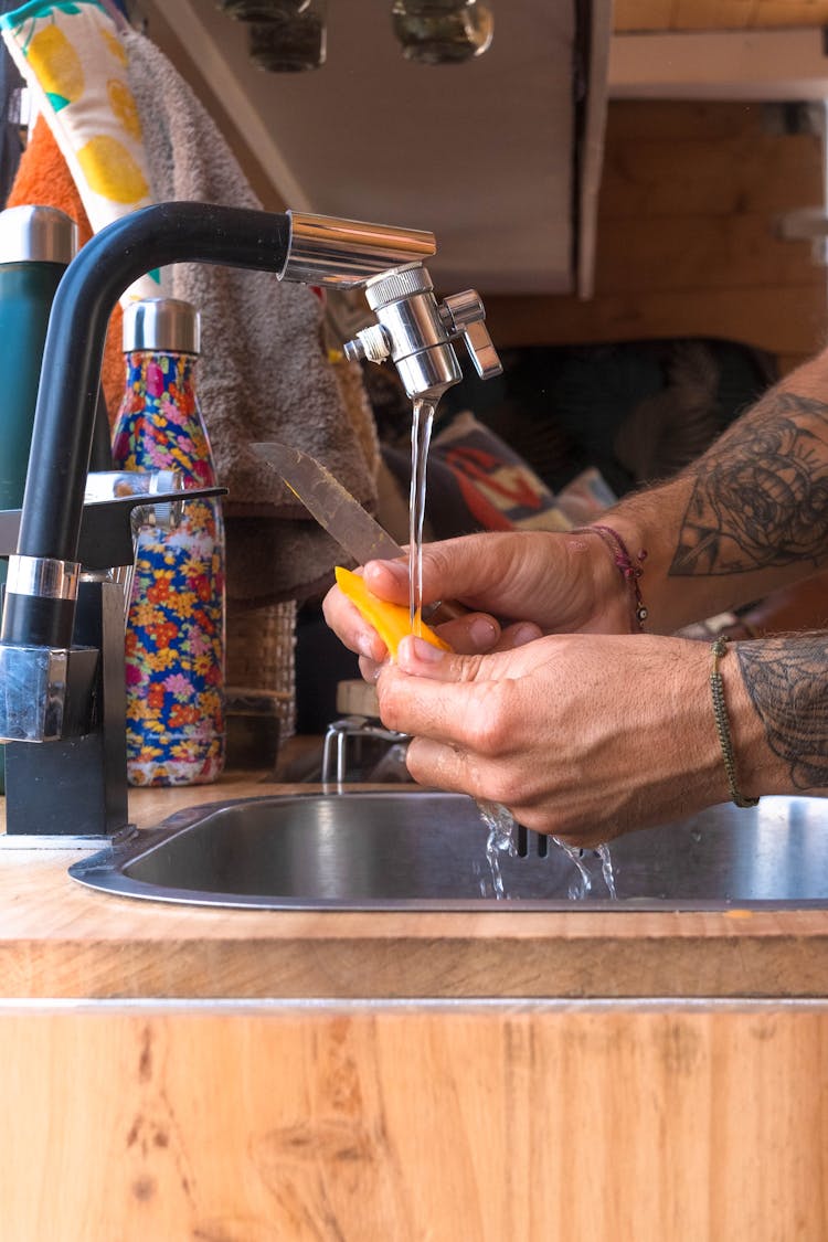 Man Washing A Vegetable In The Kitchen Sink