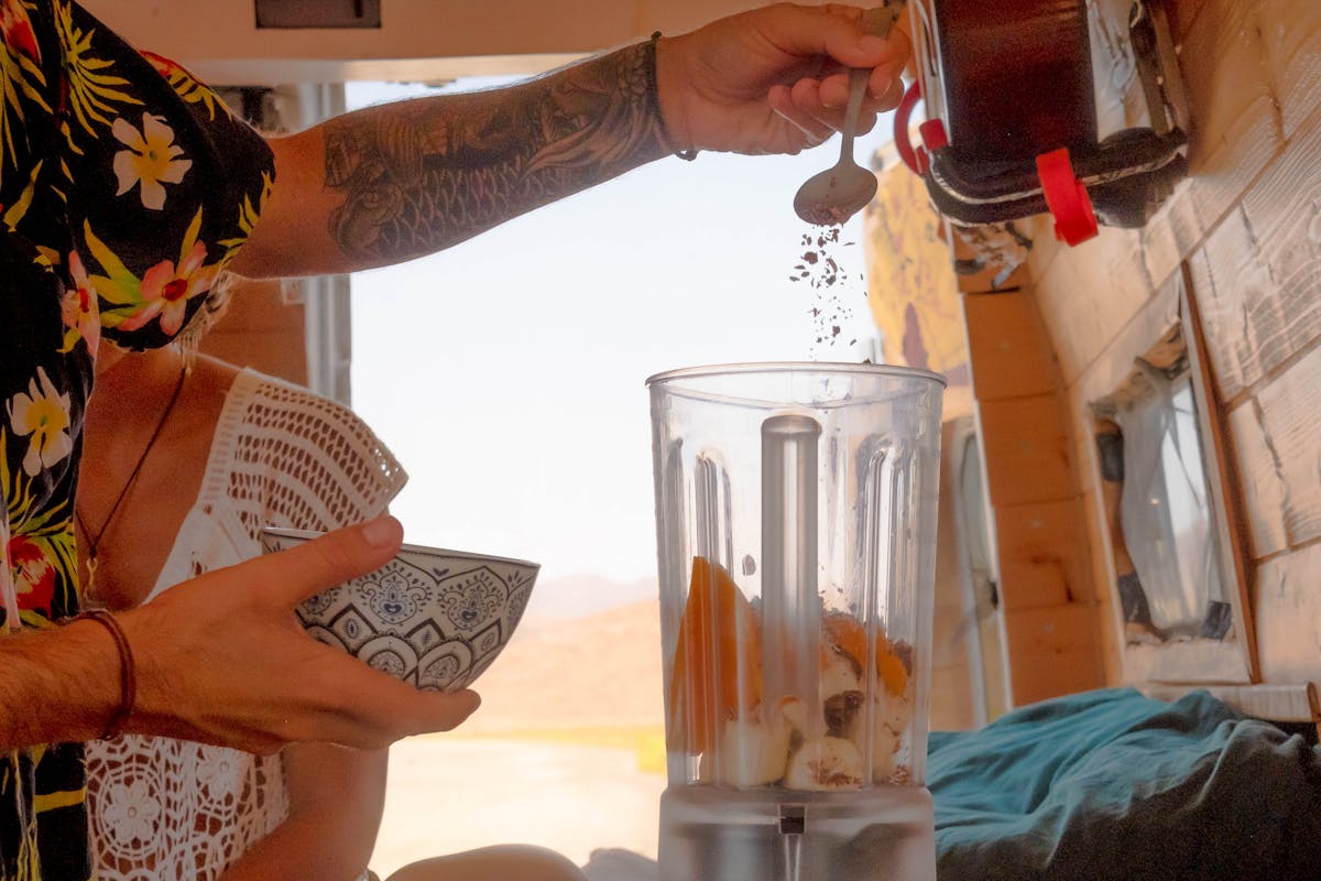 Person Pouring Flakes on a Blender