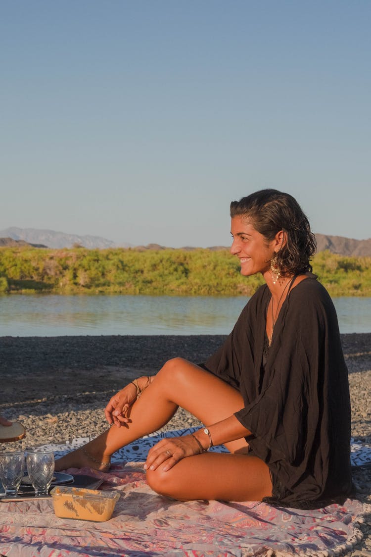 Smiling Woman Sitting On A Picnic Blanket