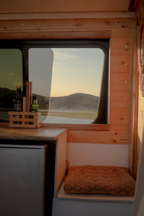 Free View of a Body of Water and Hills from the Window of a Campervan  Stock Photo