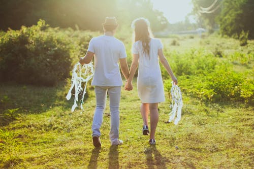 Free Couple Holding each other's Hands while Walking Stock Photo