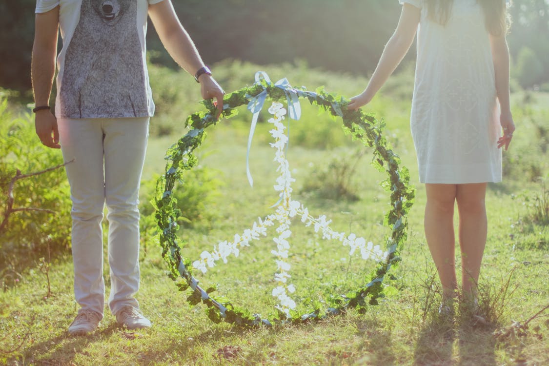Free Two Person Holding White and Green Peace Wreath Stock Photo