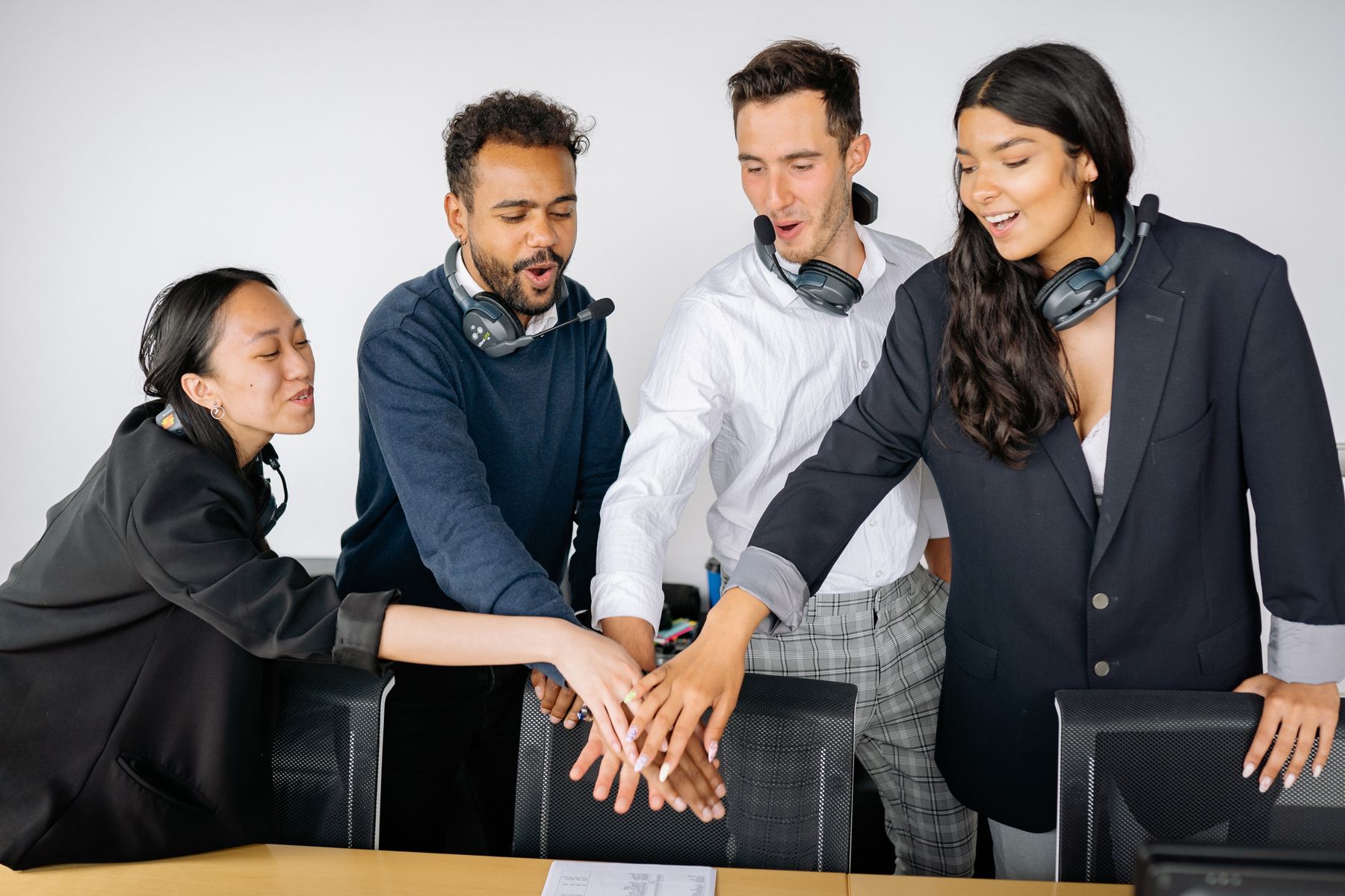 A diverse team joining hands together in a workplace