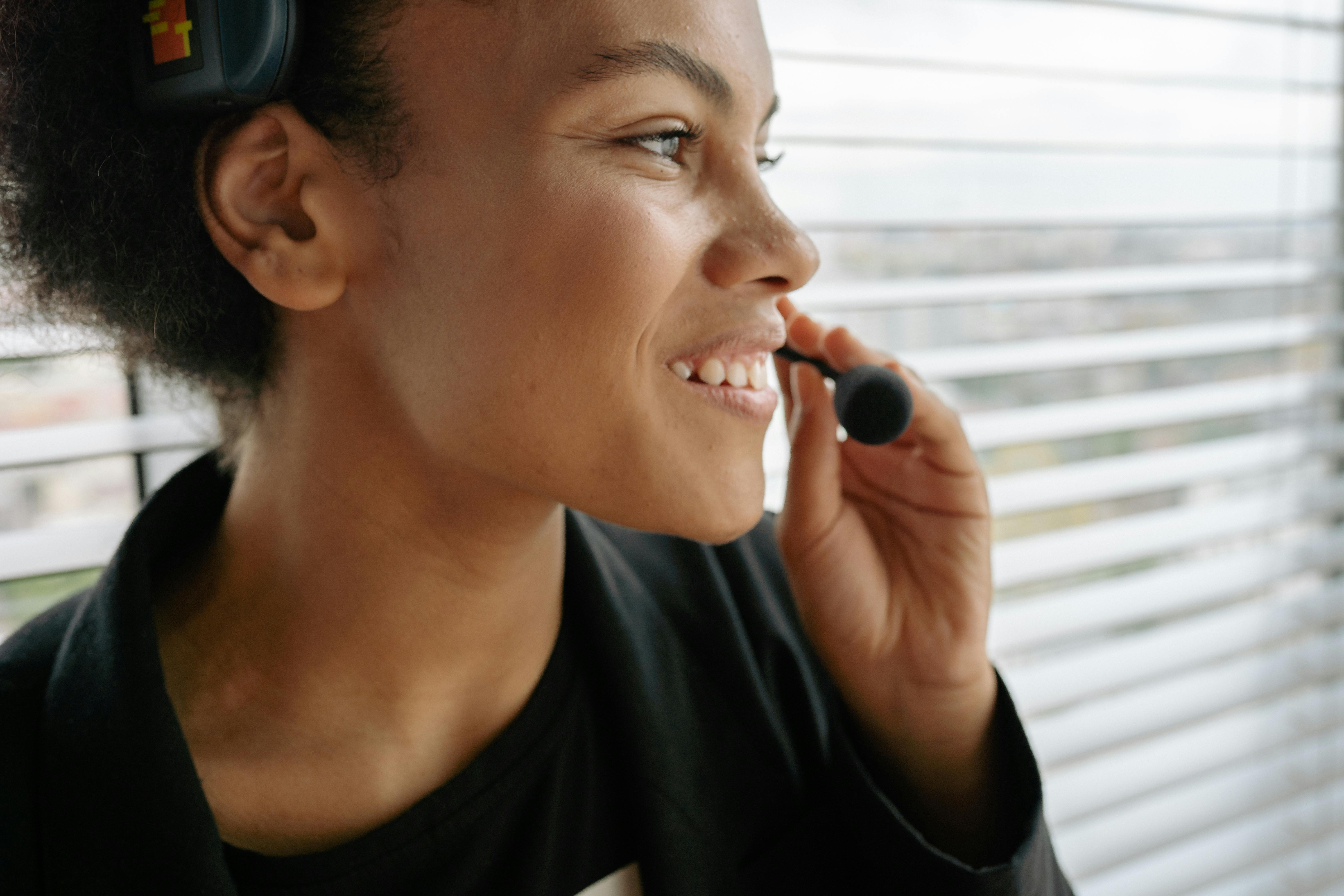 Close-up of a smiling woman using a headset, ideal for customer service themes.