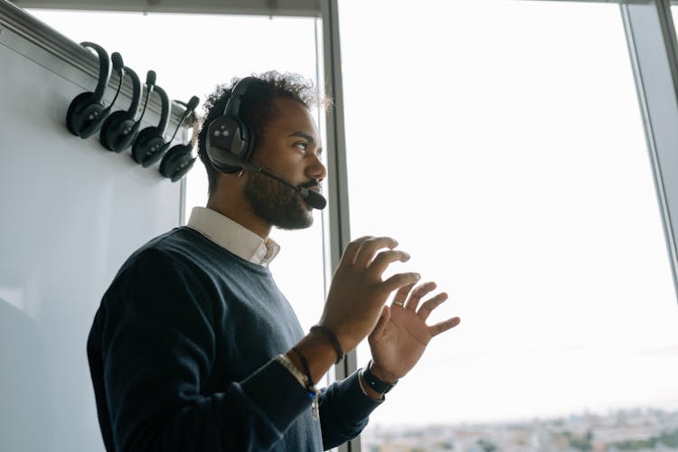 Low-Angle Shot Of A Man In Blue Sweater Wearing Black Headphones
