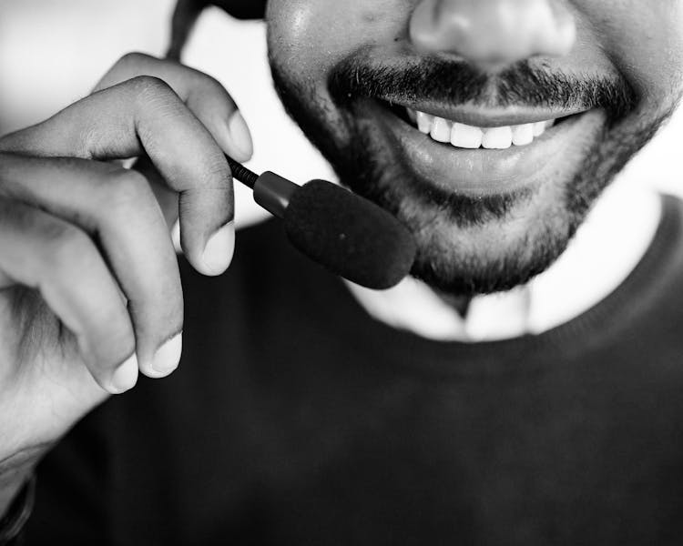 Grayscale Photo Of Person Talking On Headset