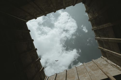 Free A dramatic low angle view of sky and clouds framed by architectural structure. Ideal for concepts of escape and freedom. Stock Photo