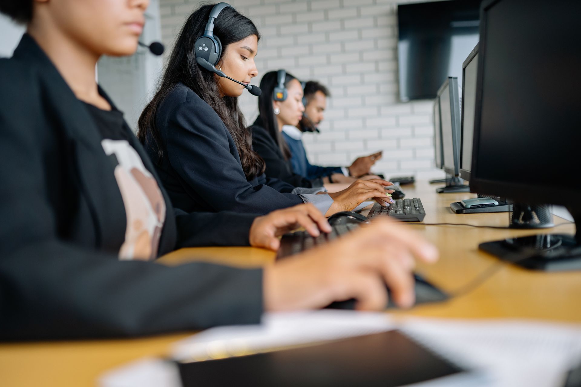A Row of People Sitting Wearing Headsets