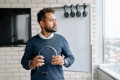 Free Person Holding Headset Looking Sideways Stock Photo