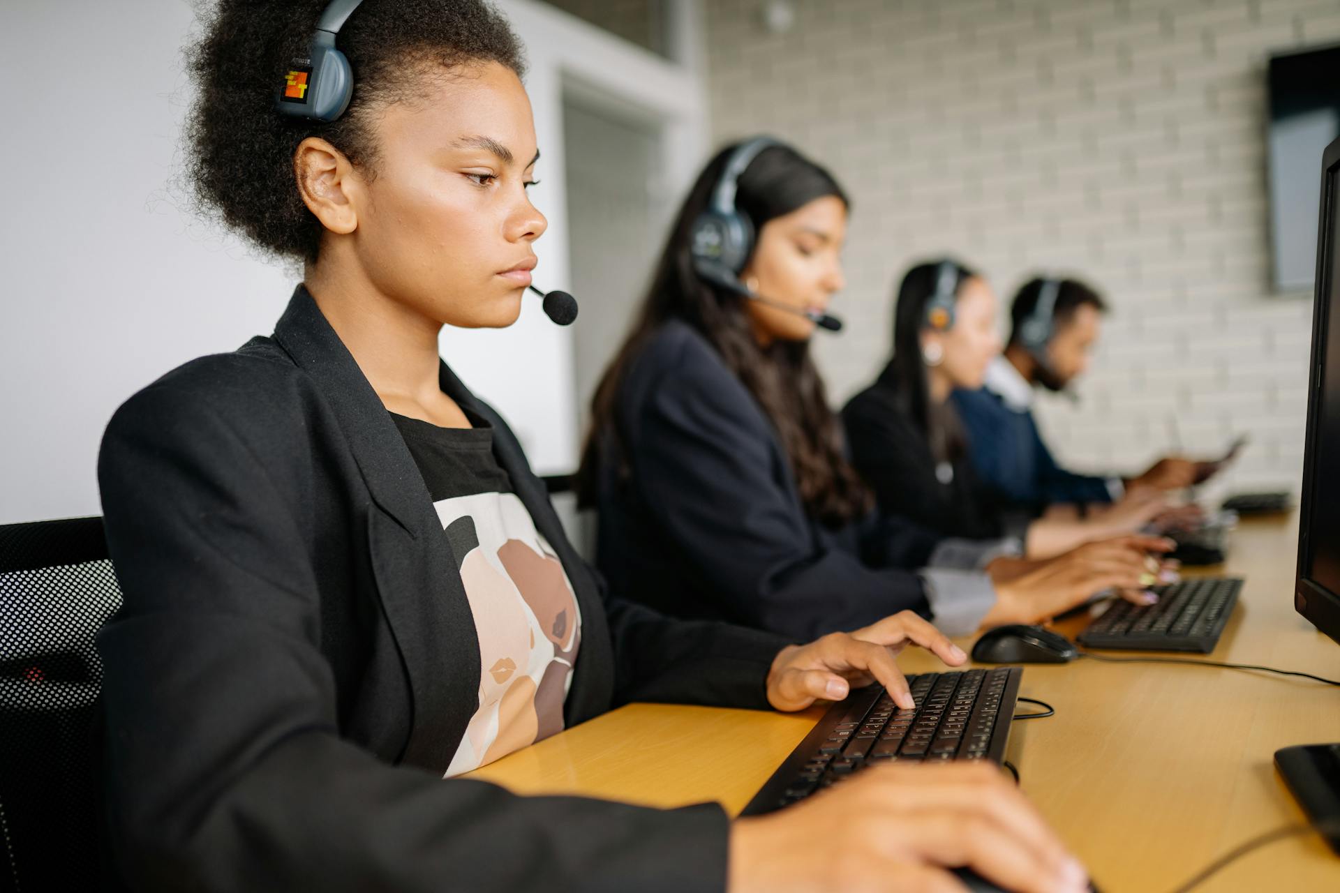 Diverse call center team working diligently on customer support with headsets and computers.