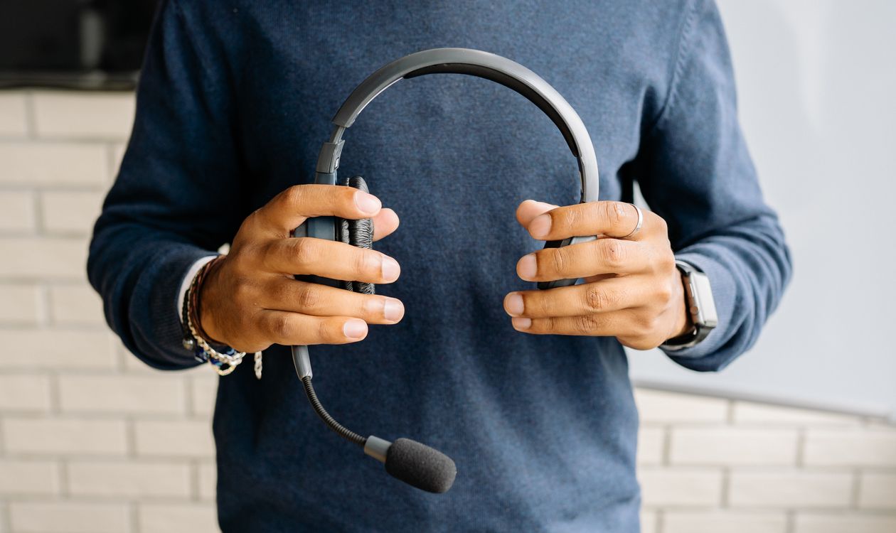 A person holding a headset, illustrating the support services behind ServiceNow workflows