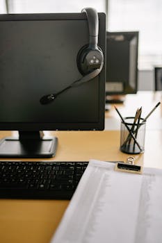 Clean and organized workspace featuring a computer monitor with headset in a modern office setting.