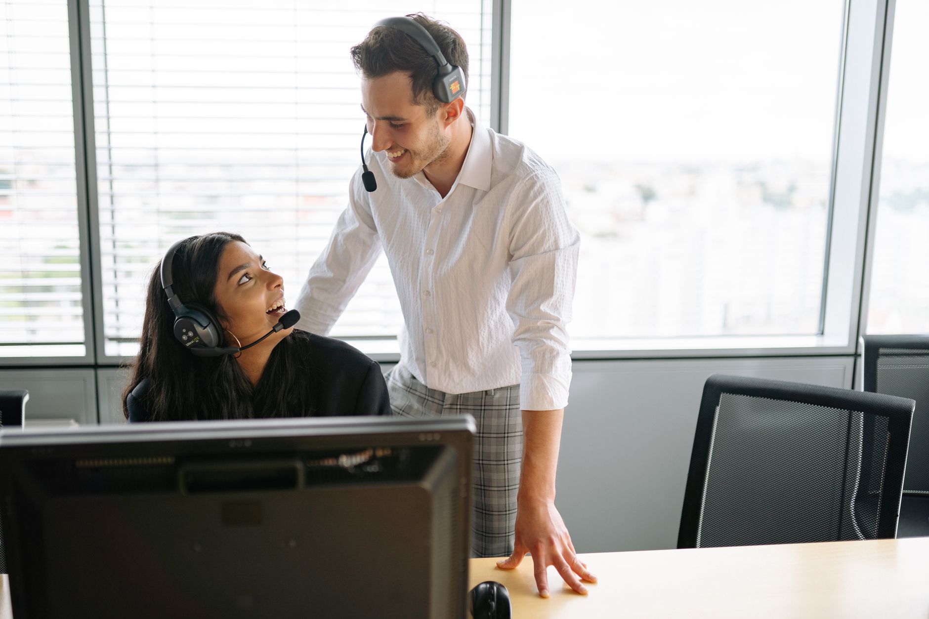 How to Fix Subscription Not Showing on Your Phone After Purchase Smiling colleagues wearing headsets working together at a call center in a modern office setting.