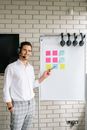 Woman in White Button Up Shirt Standing Near White Board