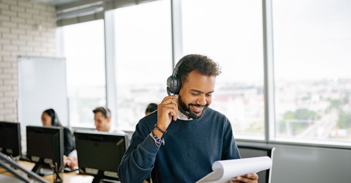 Hispanic man on WhatsApp chat with insurance agent in Tampa Florida office background