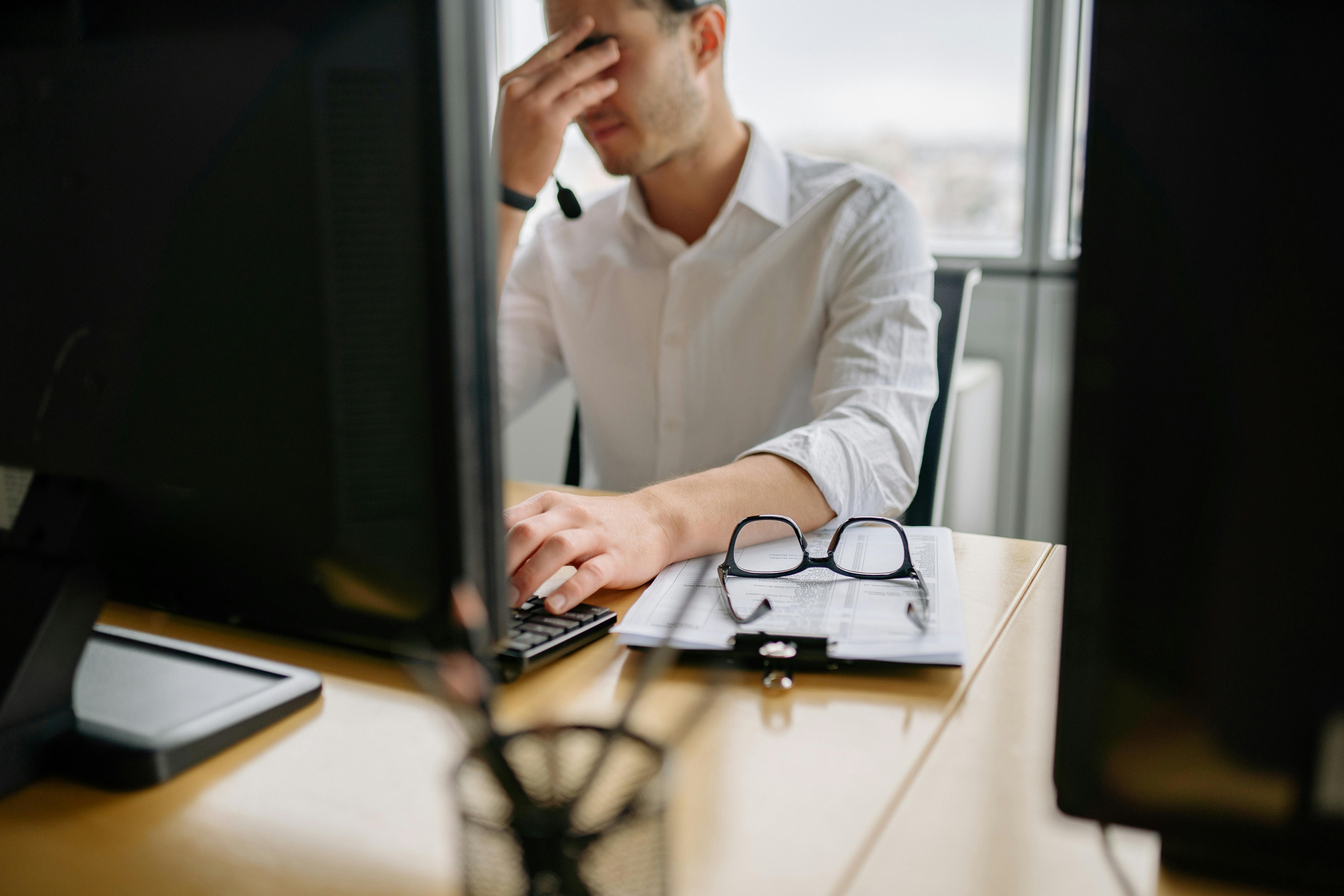 man in white long sleeve shirt using computer