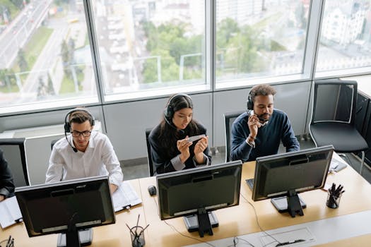 Diverse call center team working in a bright office space with a city view.