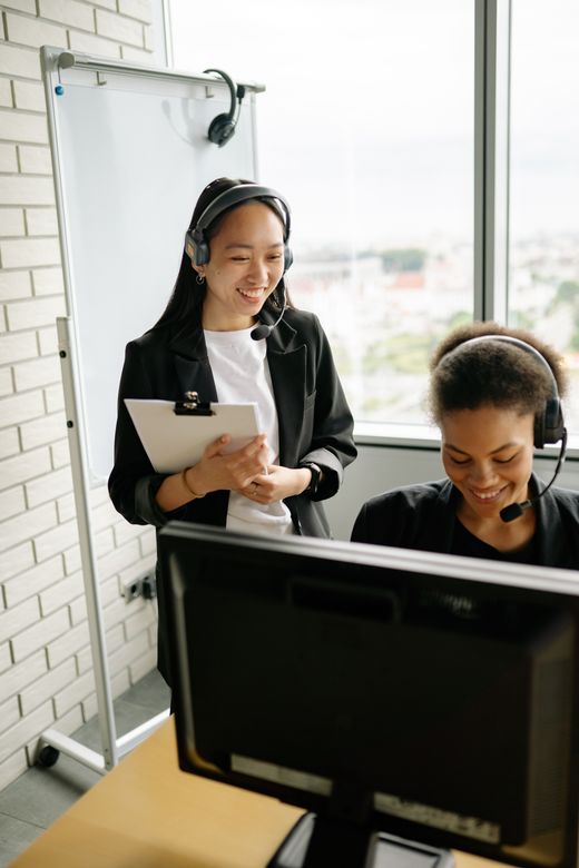 Two support agents in headsets working through a queue together — photo by Yan Krukau on Pexels