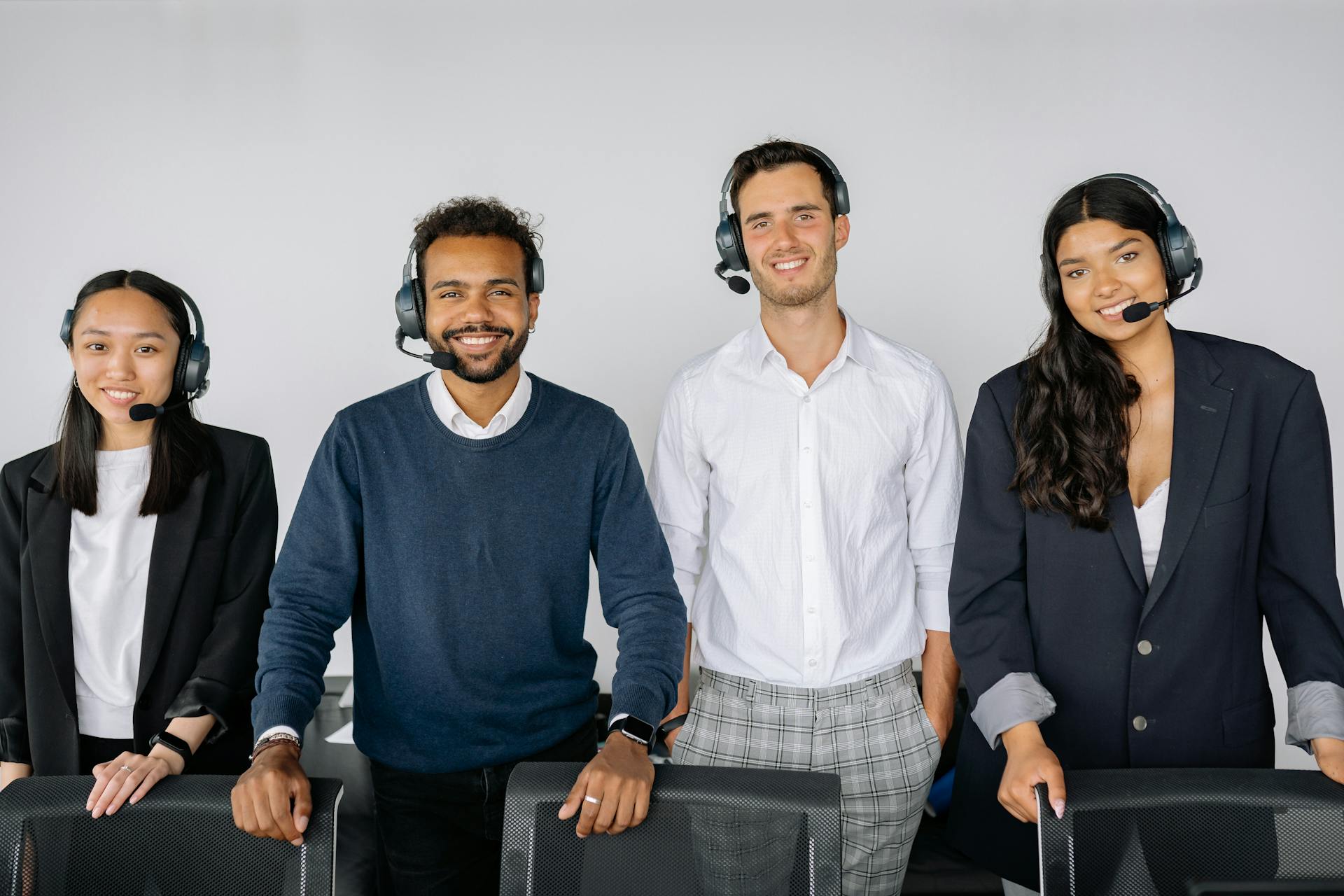 A diverse group of customer service representatives wearing headsets in a modern office.