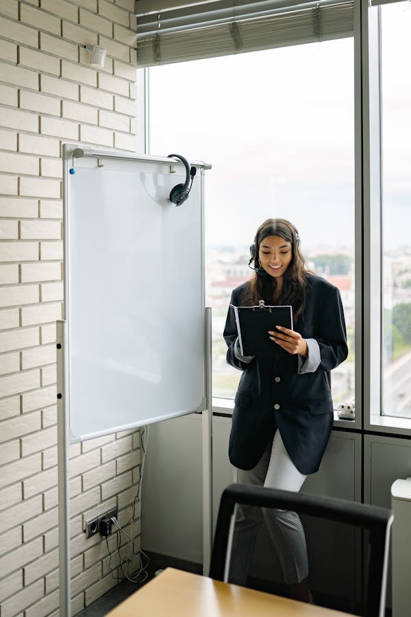 Woman in Black Blazer Standing Beside Glass Window