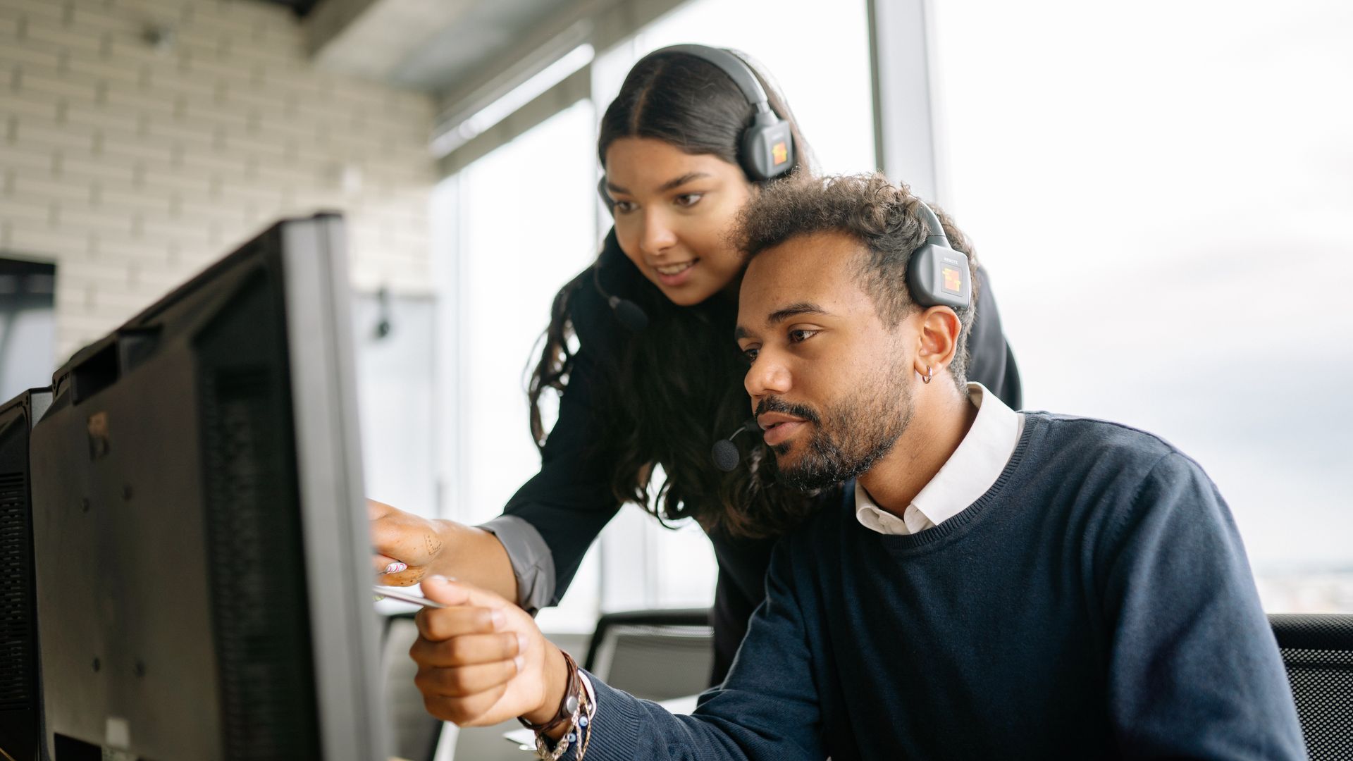 Two customer service colleagues working together at a computer