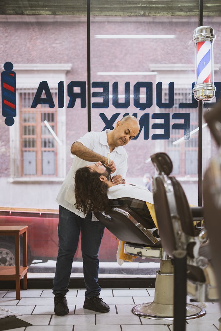 Barber Shaving A Bearded Man